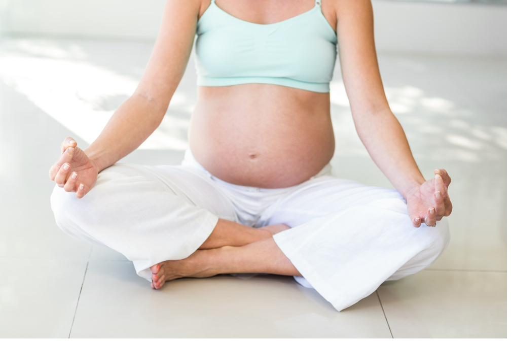 Pregnant woman sitting calmly in a meditation pose — acupuncture during pregnancy in Boca Raton by Ronen Rosenblatt Nir
