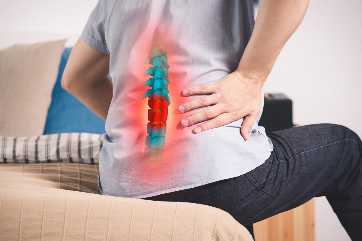 Man with lower back pain and highlighted spine showing herniated disc — acupuncture for herniated disc and back pain in Boca Raton by Ronen Rosenblatt Nir