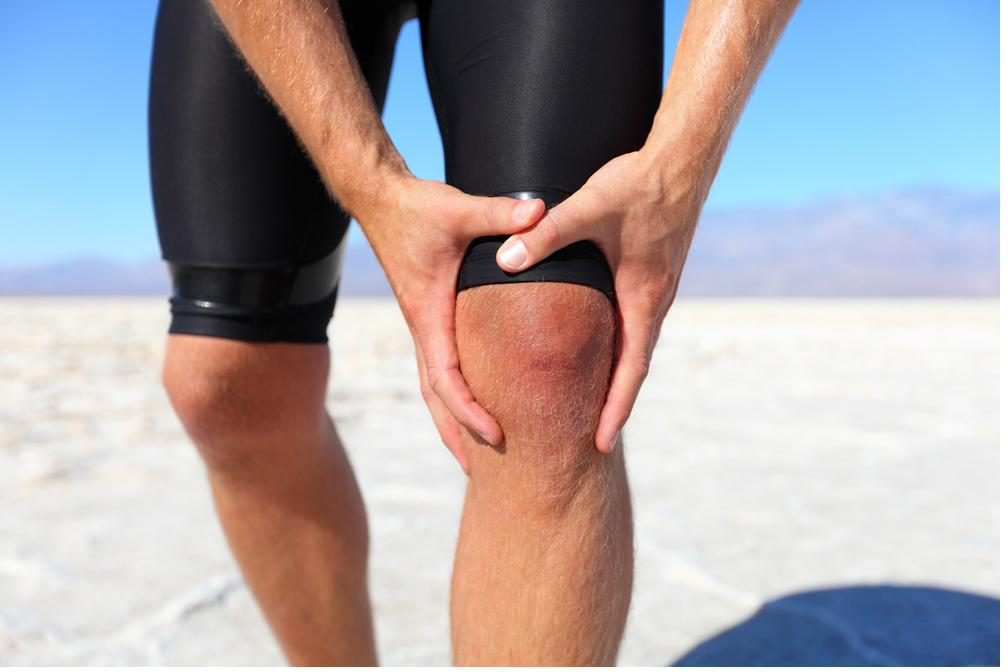 Athletic man holding his knee in pain — acupuncture for knee pain and sports injury in Boca Raton by Ronen Rosenblatt Nir