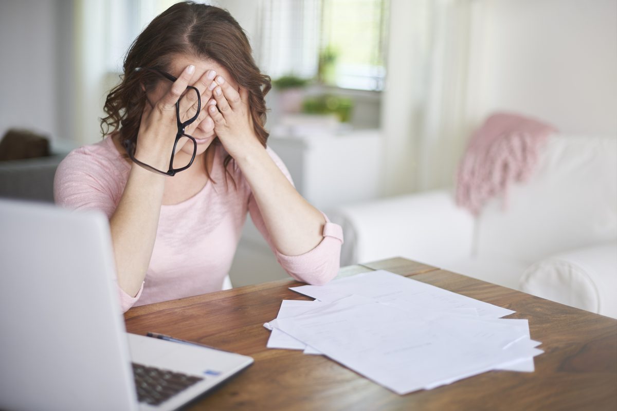 Busy woman at desk with work stress and headache - acupuncture for stress reduction in Boca Raton by Ronen Rosenblatt Nir