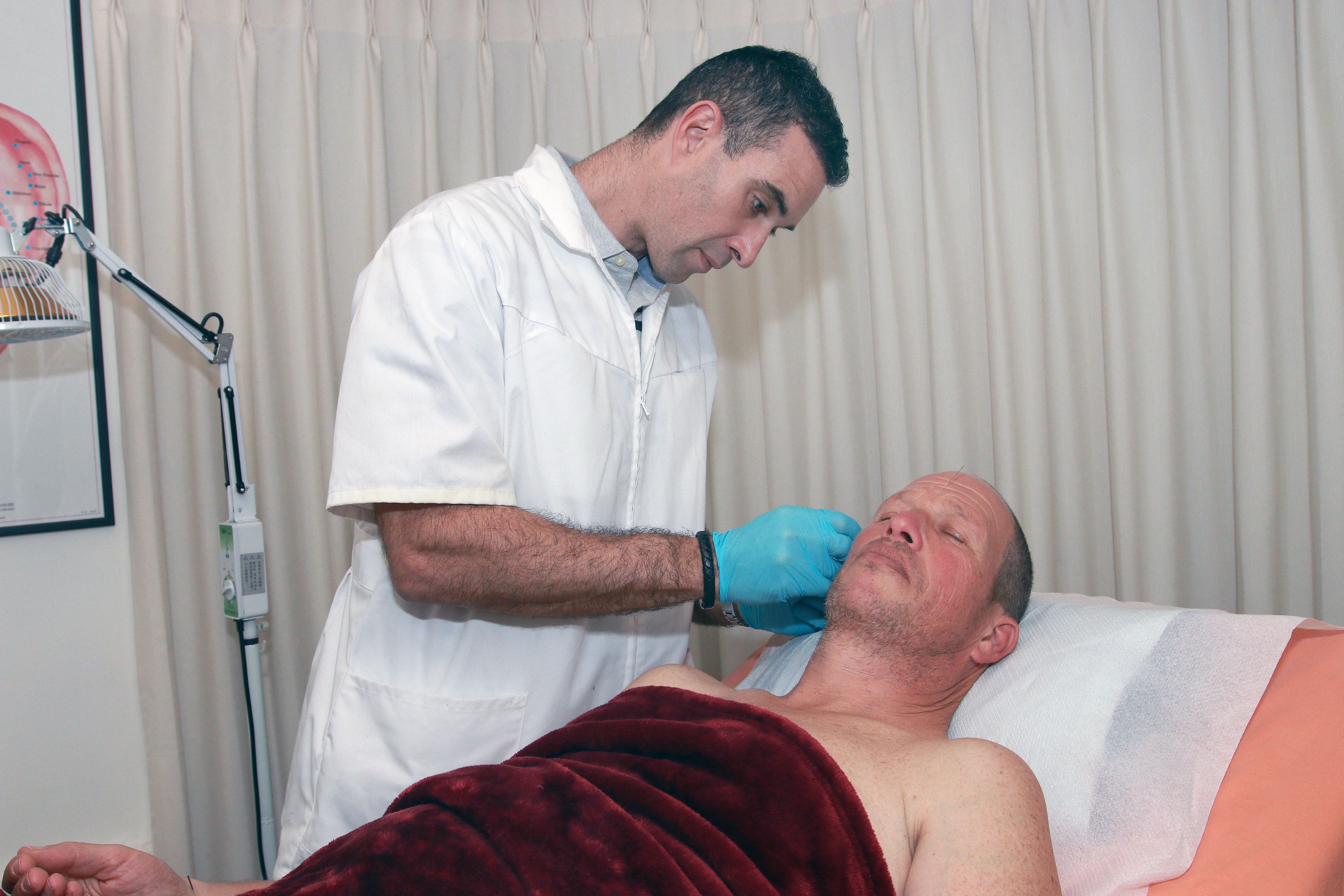 Ronen treating patient at neck and jaw area — acupuncture clinic Boca Raton