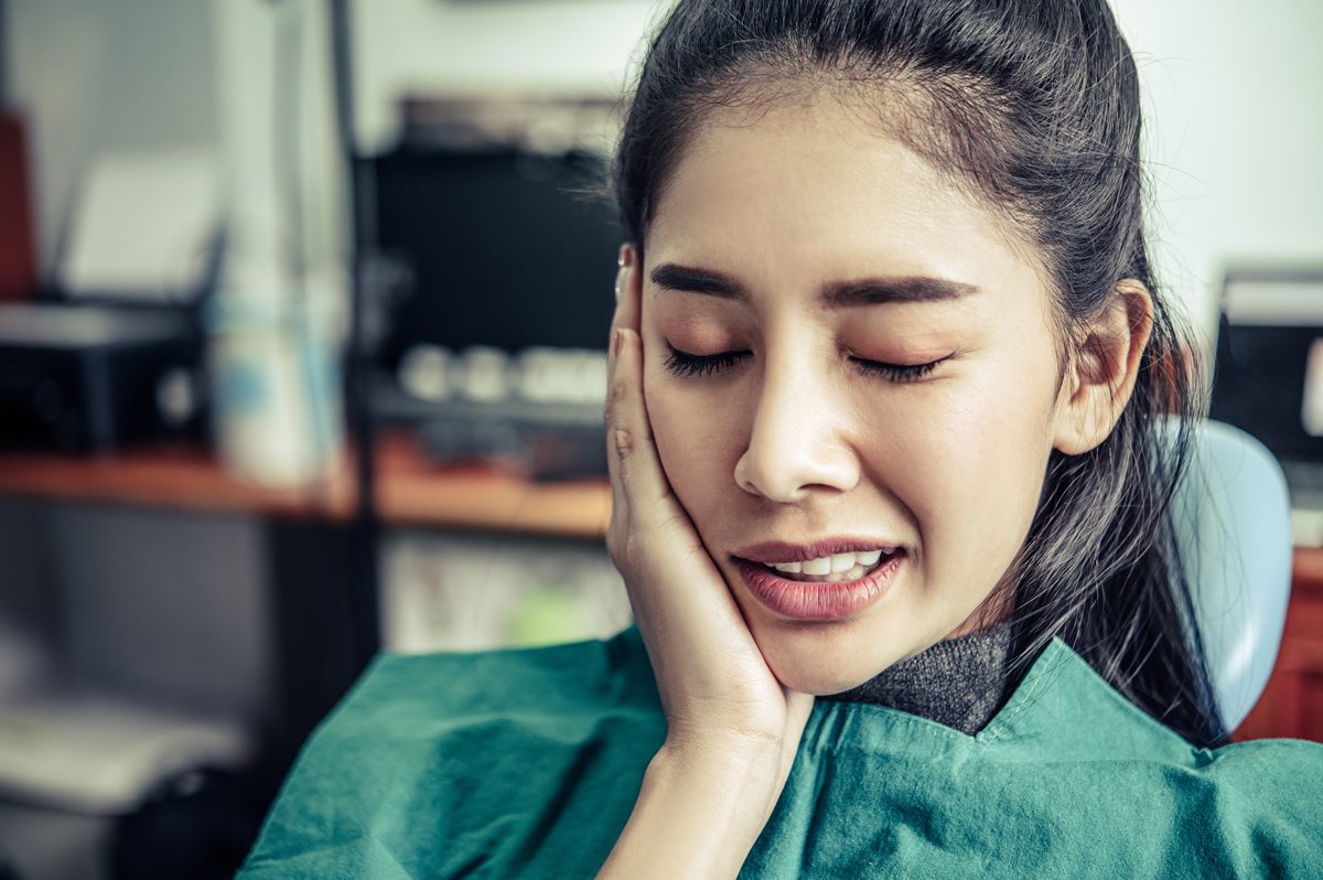 Woman holding her cheek in severe facial pain — acupuncture for trigeminal neuralgia in Boca Raton by Ronen Rosenblatt Nir